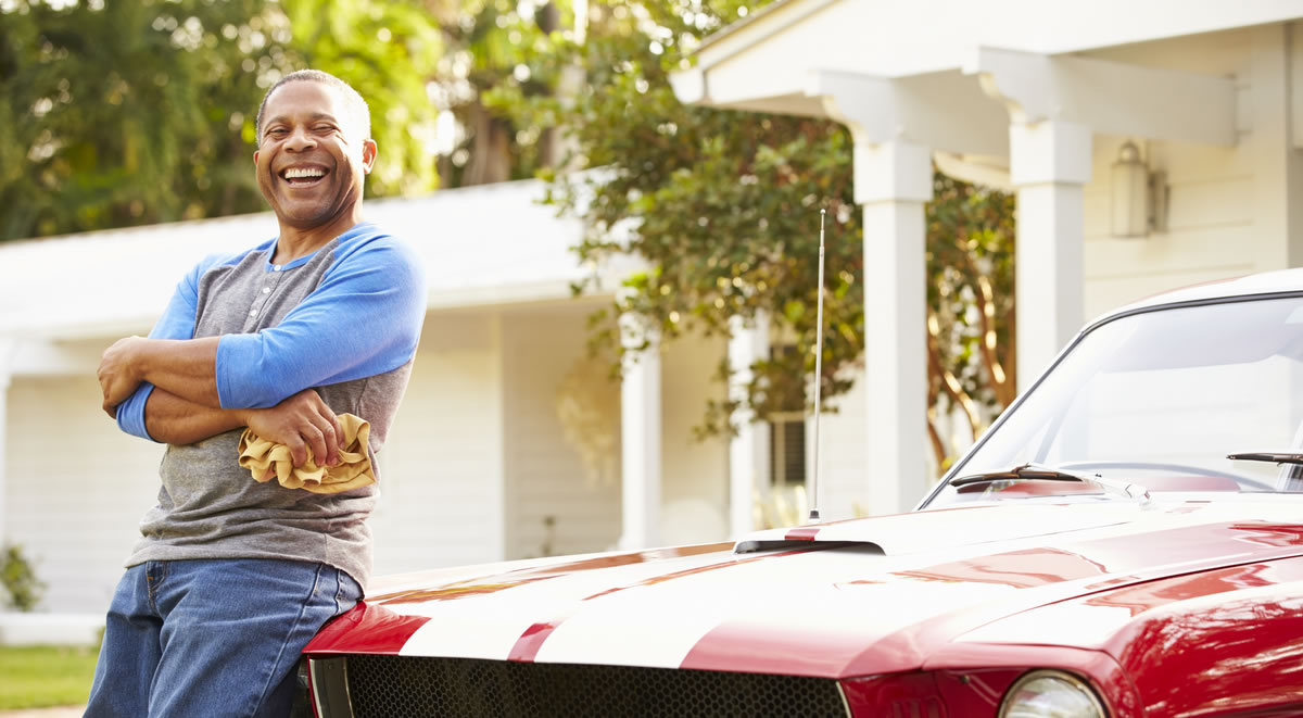 Man leaning on classic car 